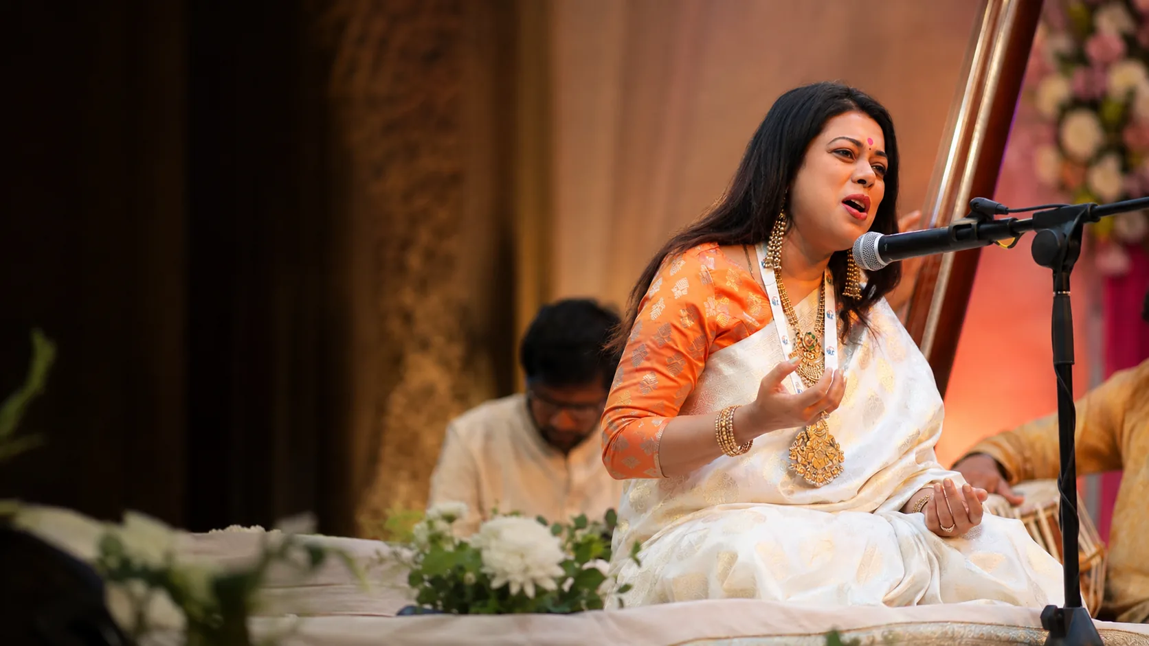 Barnali Chattopadhyay singing in concert beside a tanpura, accompanied by her ensemble