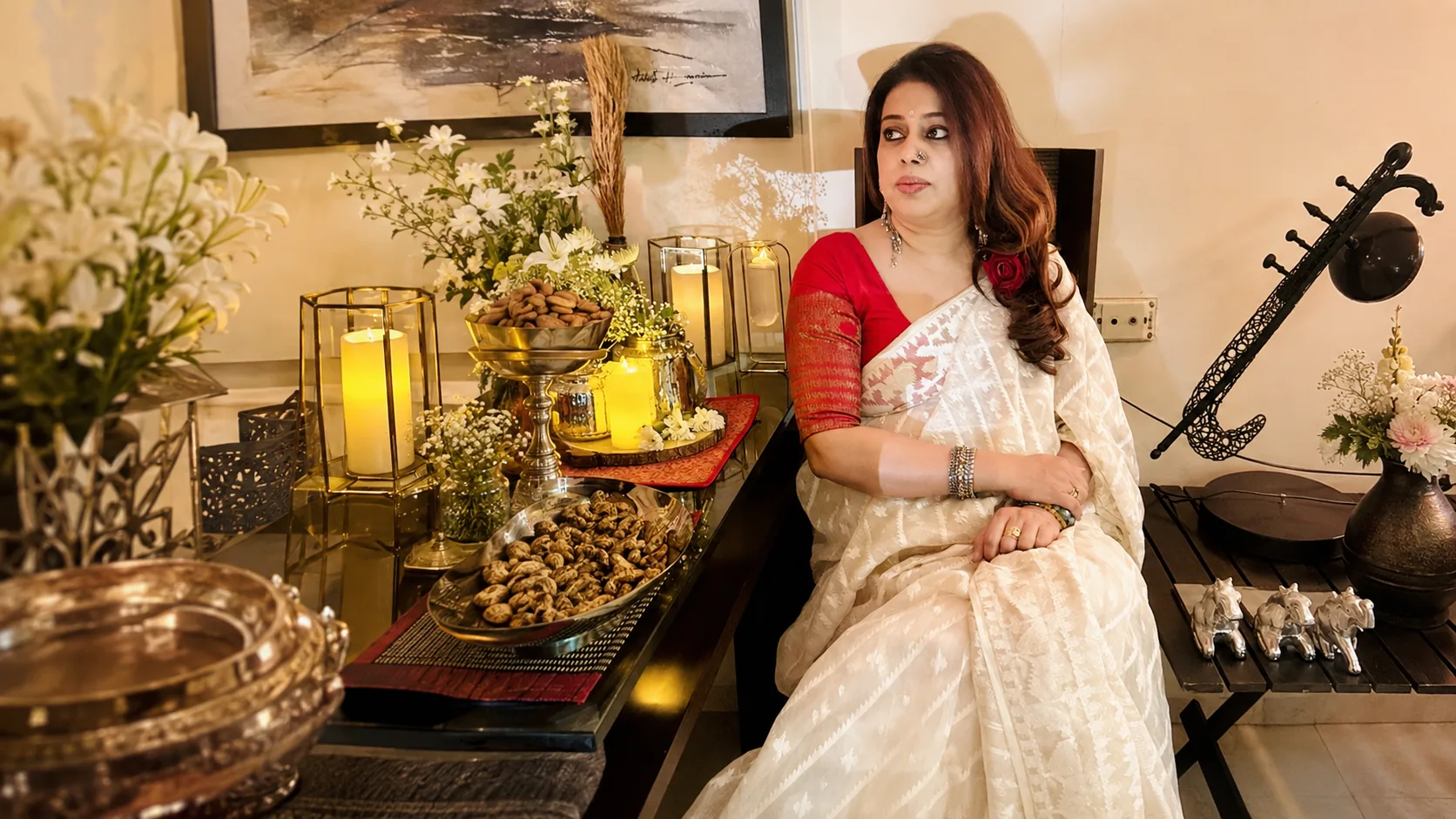 Barnali Chattopadhyay seated at home beside a tanpura, among flowers and candlelight
