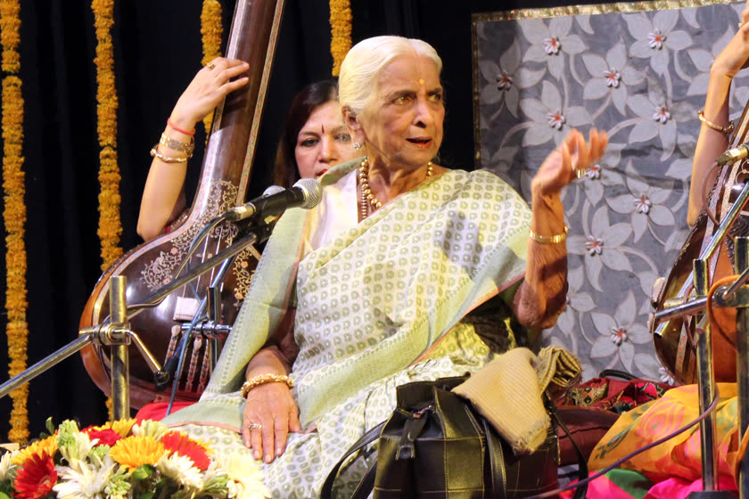 Girija Devi singing in performance, tanpura and accompanists behind her